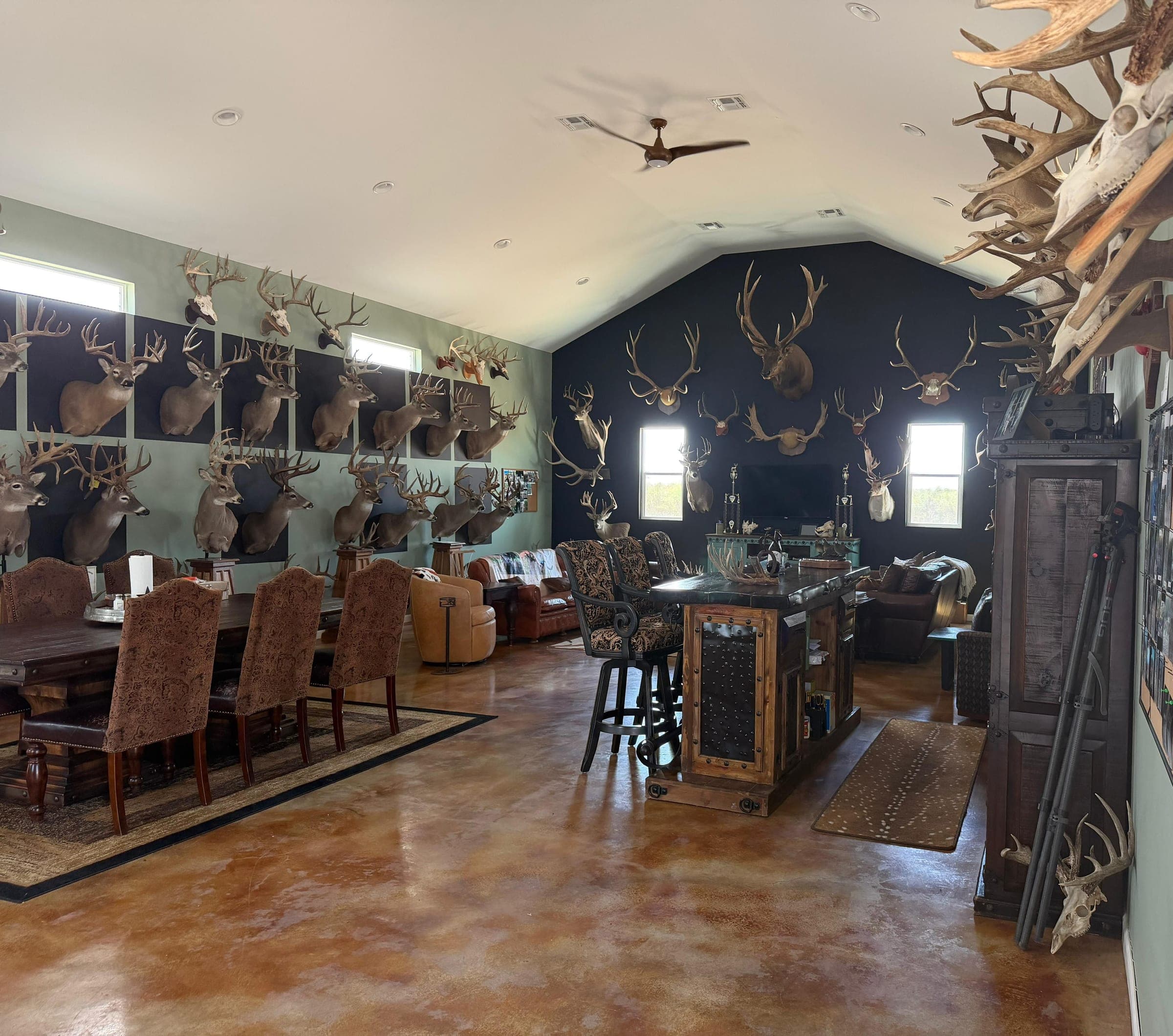 The long dining table in the lodge great room, trophy mounts lining the walls